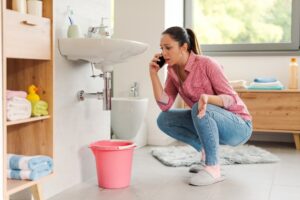 Woman,calling,a,professional,plumber,at,home,using,her,smartphone,