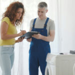 Woman,signing,the,plumber,invoice,,he,repaired,her,washing,machine