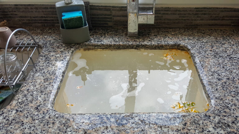 Sewage backup in a home — backed up wastewater surfacing from floor drains after a main sewer line blockage