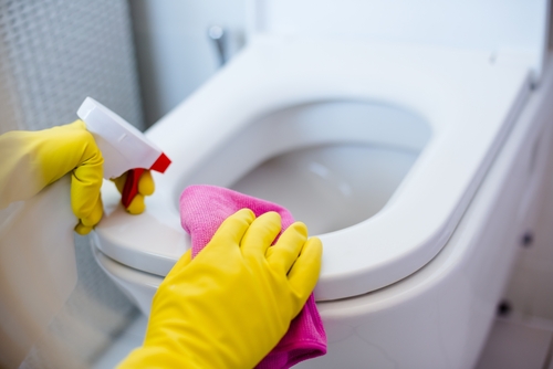 Woman,in,yellow,rubber,gloves,cleaning,toilet,with,pink,cloth